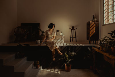 Woman sitting on table at home