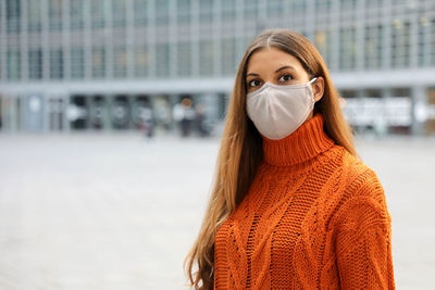 Portrait of woman wearing mask standing outdoors