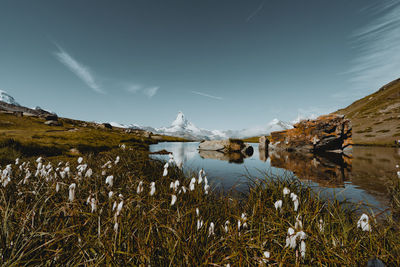 Scenic view of lake by mountains against sky