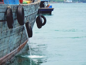 Tires hanging on boat over sea