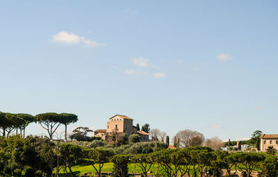 Houses by trees and buildings against sky