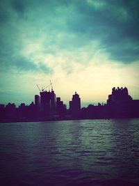 Silhouette cityscape against sky during sunset