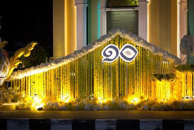 Illuminated information sign by building at night