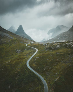 Scenic view of road by mountains against sky