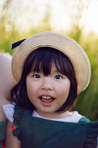 Koreans family mother and daughter in green dresses sitting in the long grass on the field at sunset