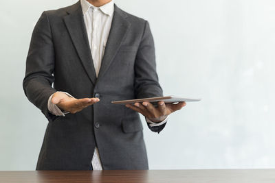 Midsection of man using mobile phone