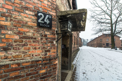 Road sign on wall in city during winter