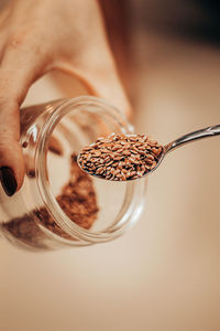 Close-up of hand holding glass jar on table
