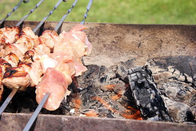 Meat skewers on skewers are grilled in the open air. picnic concept. meat raw and fried on skewers