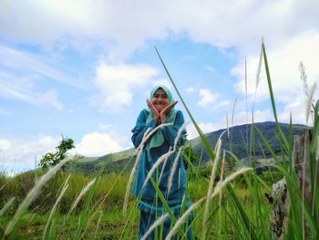 Portrait of smiling girl on field against sky