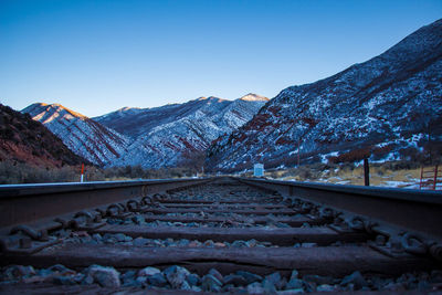 Scenic view of snow covered mountains against clear blue sky