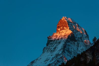 Low angle view of rock formation against clear blue sky