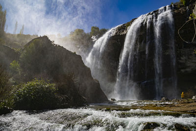 Man standing against waterfall