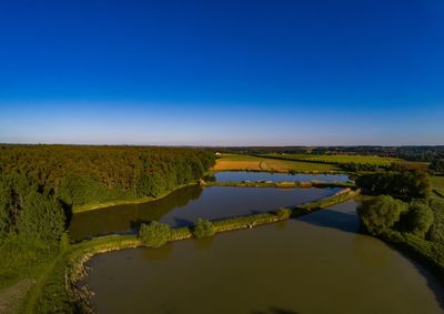 Scenic view of field against clear blue sky