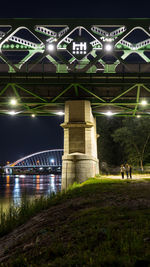 View of bridge over river at night