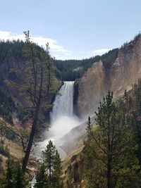 Scenic view of waterfall against sky