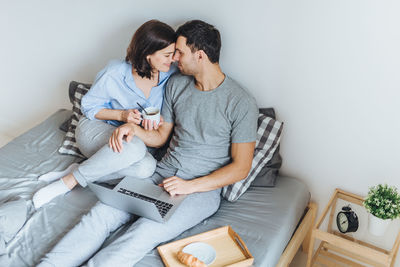 High angle view of couple romancing on bed at home