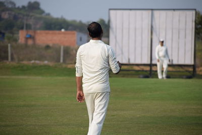 Rear view of man standing on field
