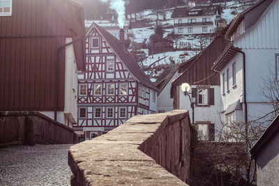 Street amidst houses in city during winter