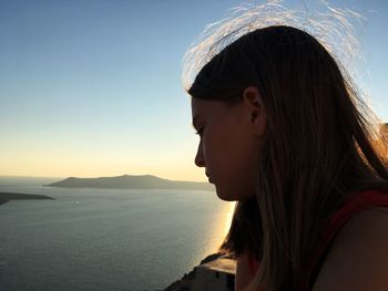 Portrait of teenage girl looking at sea against sky