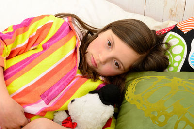 High angle portrait of girl relaxing on bed at home
