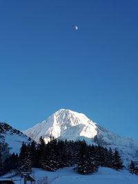Scenic view of snowcapped mountains against clear blue sky