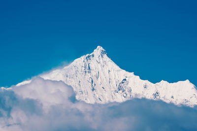 Scenic view of snowcapped mountains against clear blue sky