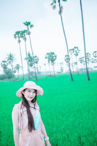 Portrait of woman wearing hat on field against sky