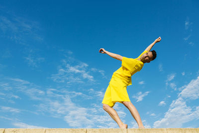 Low angle view of man against blue sky