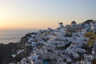 High angle view of townscape by sea against sky during sunset