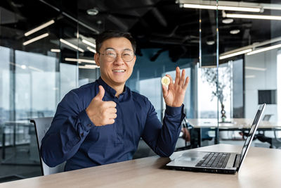 Portrait of businessman using mobile phone in office