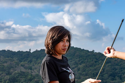 Woman standing on mountain against sky