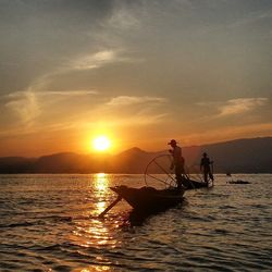 Boat sailing in sea at sunset