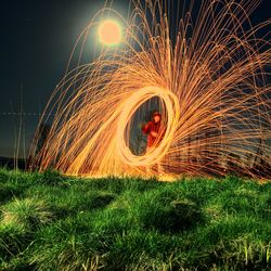 Man spinning wire wool at night