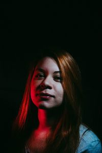 Portrait of beautiful woman against black background