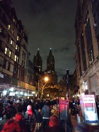 People on illuminated street at night