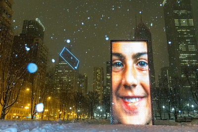 Portrait of man in snow covered city at night