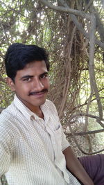 Portrait of smiling young man against plants