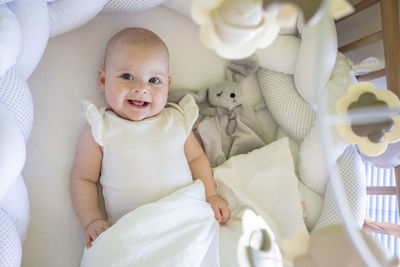 High angle view of cute baby girl lying on bed