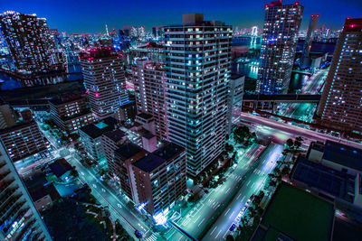 High angle view of illuminated city street and buildings at night