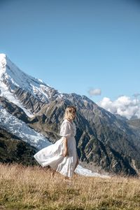 Woman standing on mountain against sky