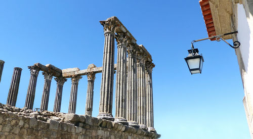 Low angle view of old ruined temple against blue sky