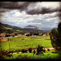 Scenic view of grassy field against cloudy sky