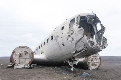 Abandoned airplane on airport runway against sky