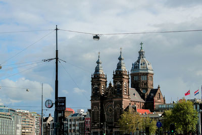 Buildings in city against cloudy sky