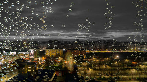 Close-up of wet illuminated city at night