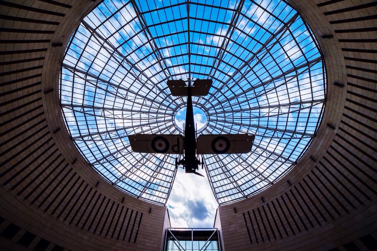 indoors, ceiling, low angle view, architecture, built structure, skylight, directly below, glass - material, window, lighting equipment, hanging, circle, transparent, interior, geometric shape, pattern, modern, day, no people, shape