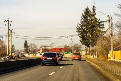 Cars on street in city against sky