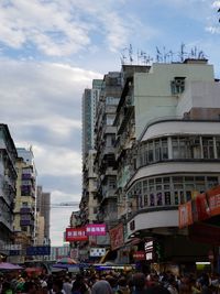 People on street against buildings in city