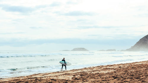 Rear view of man standing on beach